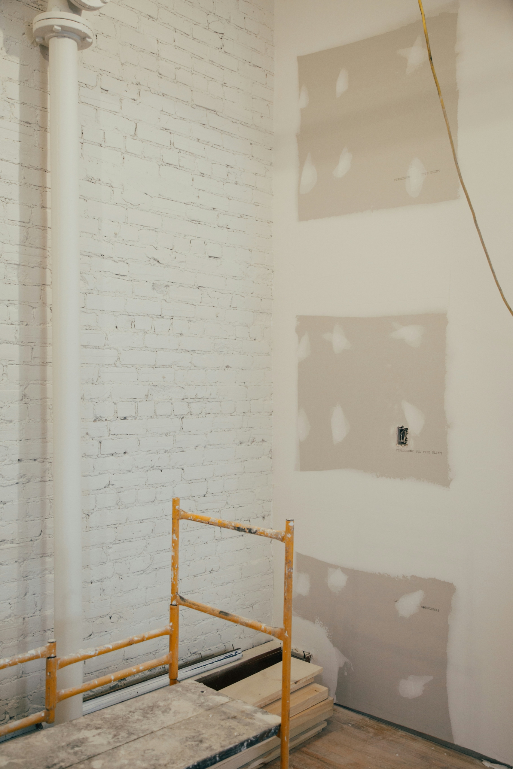 Chantier de rénovation en cours avec mur en pierre apparente et reprise de cloisons, suivi par un architecte d'intérieur à Chamonix